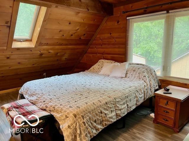 6774 S Becks Grove Rd, Freetown, IN 47235 - bedroom featuring wooden walls, multiple windows, and wood finished floors