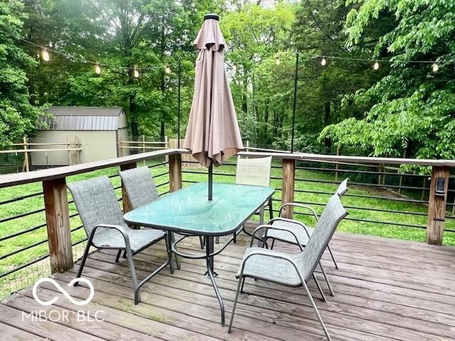 6774 S Becks Grove Rd, Freetown, IN 47235 - deck featuring outdoor dining area and a lawn