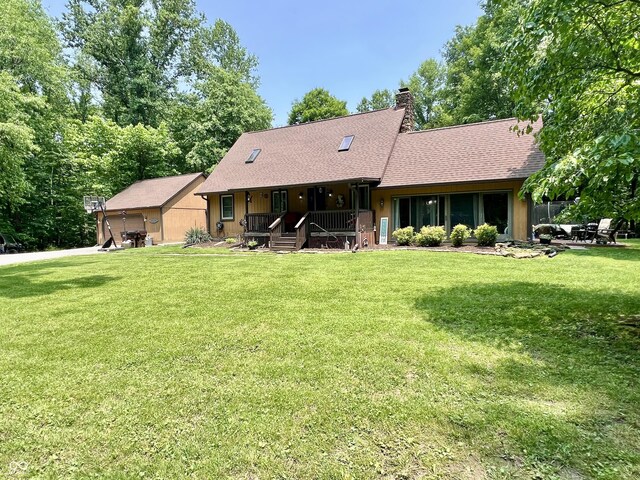 6774 S Becks Grove Rd, Freetown, IN 47235 - view of front facade featuring covered porch, a front yard, a chimney, and a shingled roof