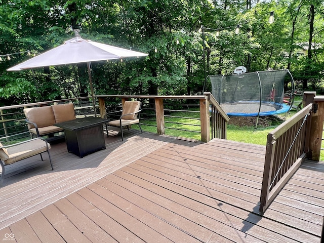6774 S Becks Grove Rd, Freetown, IN 47235 - wooden deck with a trampoline, an outdoor living space, a lawn, and view of scattered trees