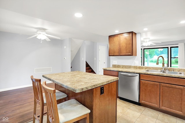 3126 Carriage Rd, West Lafayette, IN 47906 - kitchen featuring dishwasher, a sink, ceiling fan, a breakfast bar area, and brown cabinetry