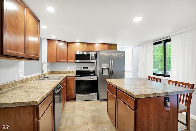 3126 Carriage Rd, West Lafayette, IN 47906 - kitchen with stainless steel appliances, a sink, a kitchen bar, a kitchen island, and light tile patterned floors