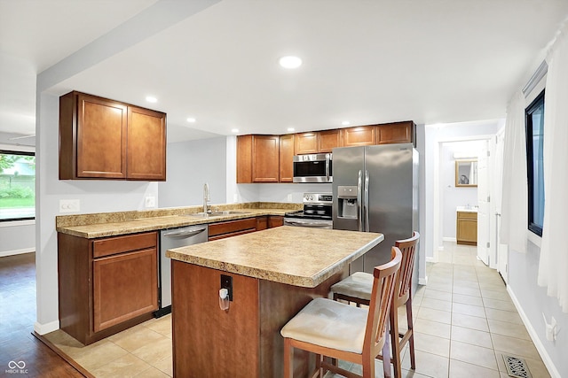 3126 Carriage Rd, West Lafayette, IN 47906 - kitchen featuring stainless steel appliances, a sink, a kitchen bar, baseboards, and a center island