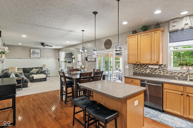 9756 Brook Meadow Dr, Mccordsville, IN 46055 - kitchen with dishwasher, a sink, a textured ceiling, a kitchen island, and healthy amount of natural light