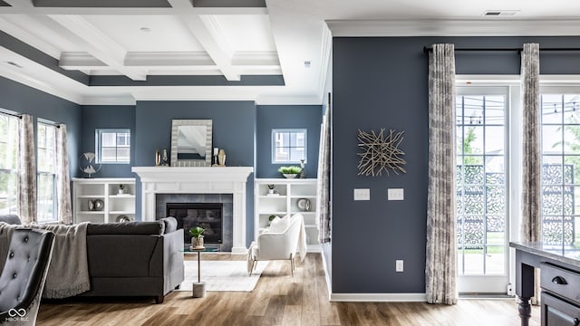 15596 Edenvale Dr, Westfield, IN 46074 - living area with beam ceiling, wood finished floors, a tiled fireplace, crown molding, and coffered ceiling