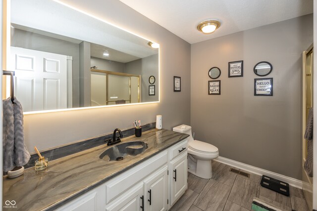 28 Patriot Ct, Greenfield, IN 46140 - bathroom featuring vanity, toilet, baseboards, and a shower with shower door