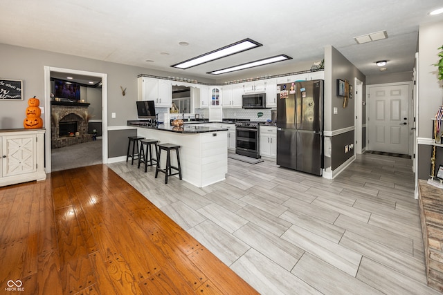 28 Patriot Ct, Greenfield, IN 46140 - kitchen with stainless steel appliances, a peninsula, dark countertops, baseboards, and white cabinetry