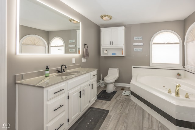 28 Patriot Ct, Greenfield, IN 46140 - bathroom with a whirlpool tub, vanity, baseboards, and toilet