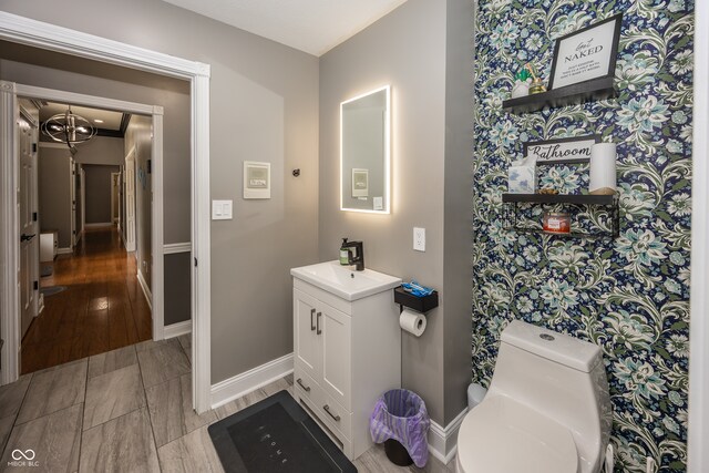 28 Patriot Ct, Greenfield, IN 46140 - bathroom with vanity, a chandelier, baseboards, toilet, and wood finished floors
