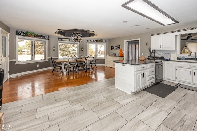 28 Patriot Ct, Greenfield, IN 46140 - kitchen featuring stainless steel dishwasher, dark countertops, white cabinets, a peninsula, and a sink