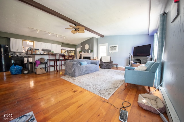 402 W Black Foot Trl, Greensburg, IN 47240 - living area with a baseboard radiator, ceiling fan, hardwood / wood-style floors, a fireplace, and a wall mounted air conditioner