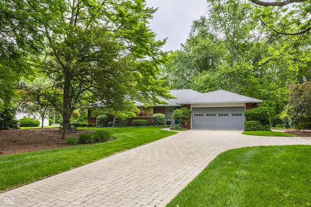 8905 Washington Blvd W Drive, Indianapolis, IN 46240 - view of front facade featuring decorative driveway, a garage, a front lawn, and brick siding