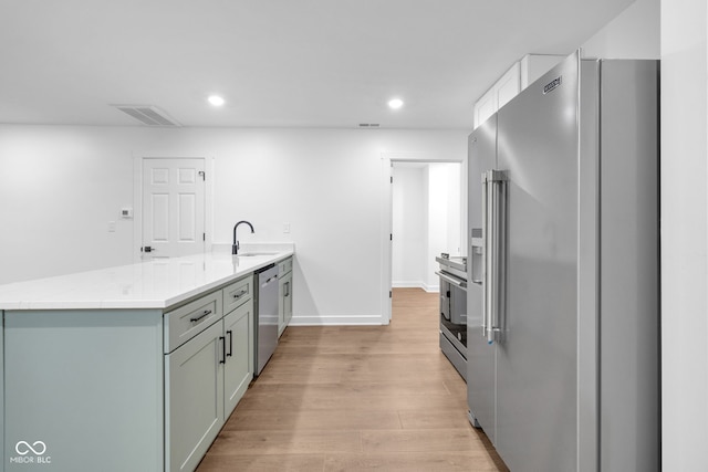 1027 Hosbrook St, Indianapolis, IN 46203 - kitchen with appliances with stainless steel finishes, a peninsula, a sink, light wood-style flooring, and recessed lighting