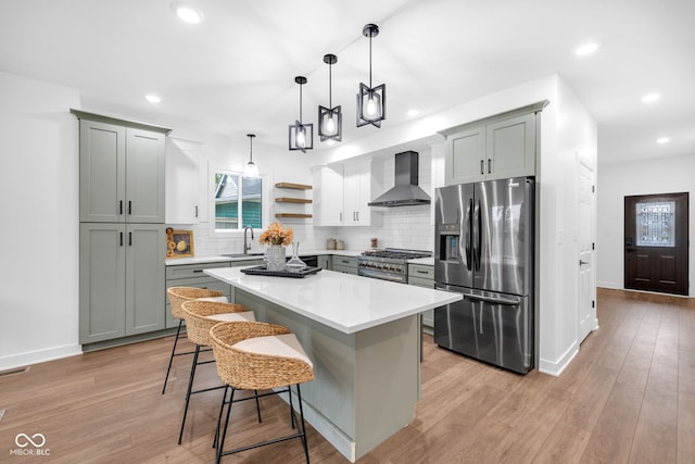 1027 Hosbrook St, Indianapolis, IN 46203 - kitchen with appliances with stainless steel finishes, wall chimney range hood, a sink, tasteful backsplash, and a center island