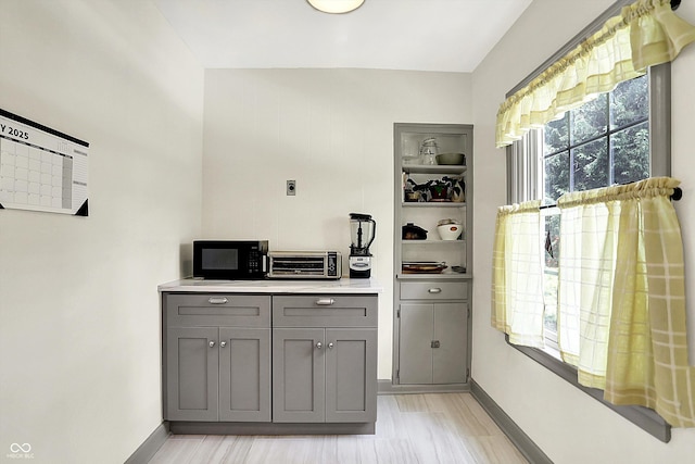 1725 W 53rd St, Indianapolis, IN 46228 - bar featuring black microwave, baseboards, and light wood-type flooring