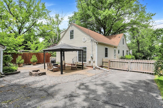 1725 W 53rd St, Indianapolis, IN 46228 - back of property with an outdoor living space with a fire pit, a patio, a gazebo, and roof with shingles