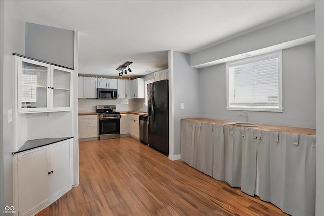 1240 Stringtown Pike, Cicero, IN 46034 - kitchen with appliances with stainless steel finishes, light wood-type flooring, tasteful backsplash, a sink, and white cabinets