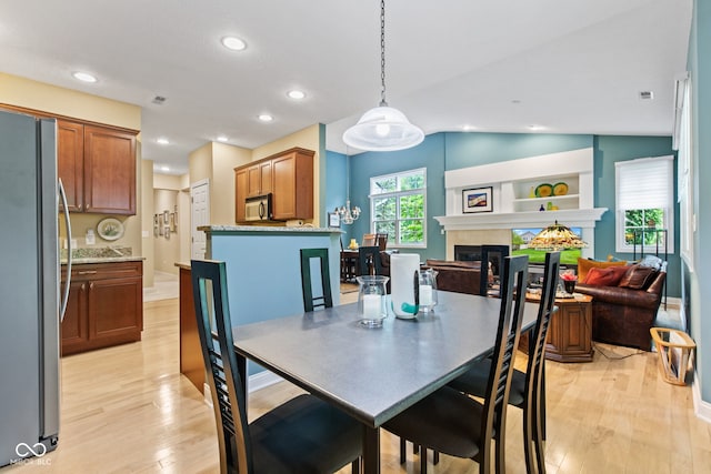 11510 Monon Farms Ln, Carmel, IN 46032 - dining space with light wood-style floors, a fireplace, recessed lighting, and vaulted ceiling