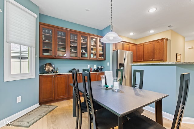 11510 Monon Farms Ln, Carmel, IN 46032 - kitchen featuring stainless steel fridge, light wood-type flooring, hanging light fixtures, brown cabinets, and recessed lighting