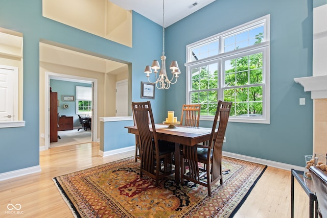11510 Monon Farms Ln, Carmel, IN 46032 - dining room featuring a chandelier, light wood-type flooring, healthy amount of natural light, and a towering ceiling
