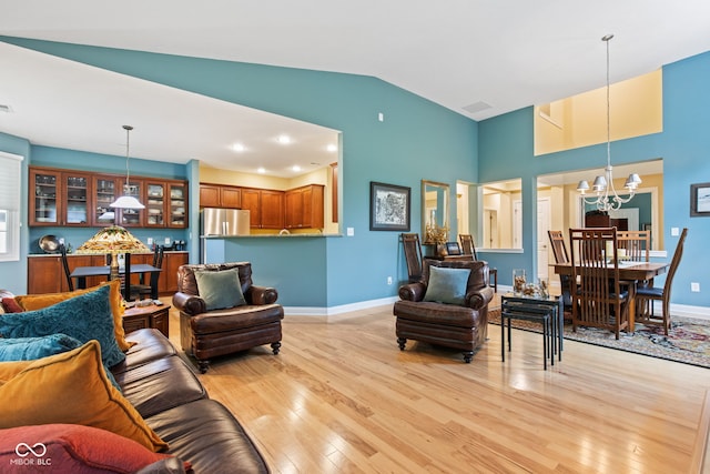 11510 Monon Farms Ln, Carmel, IN 46032 - living room with a chandelier, light wood finished floors, baseboards, and lofted ceiling