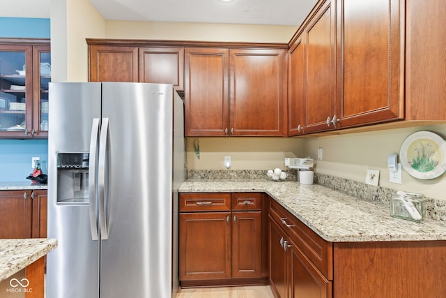 11510 Monon Farms Ln, Carmel, IN 46032 - kitchen featuring stainless steel fridge, light stone counters, and brown cabinets