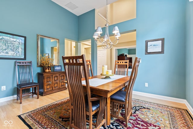 11510 Monon Farms Ln, Carmel, IN 46032 - dining space featuring a chandelier, light wood-style flooring, baseboards, and a towering ceiling