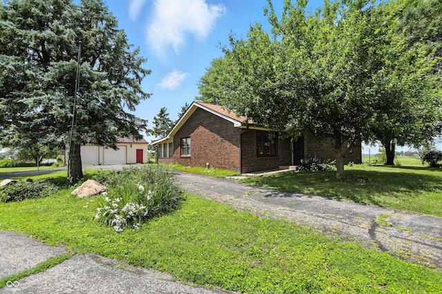 25420 Jerkwater Rd, Sheridan, IN 46069 - view of side of home featuring brick siding, a lawn, a garage, and driveway