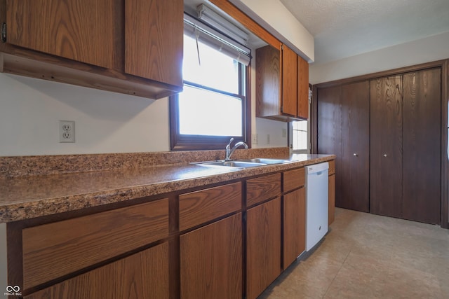 1367 Brookside Ct, Columbus, IN 47201 - kitchen with a sink, dishwasher, dark countertops, and brown cabinets