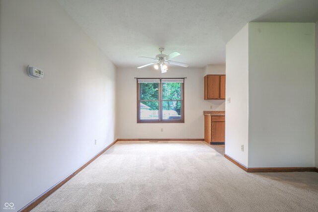 1367 Brookside Ct, Columbus, IN 47201 - unfurnished living room with light carpet, a ceiling fan, and baseboards