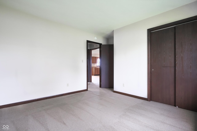1367 Brookside Ct, Columbus, IN 47201 - unfurnished bedroom featuring light carpet, a closet, and baseboards