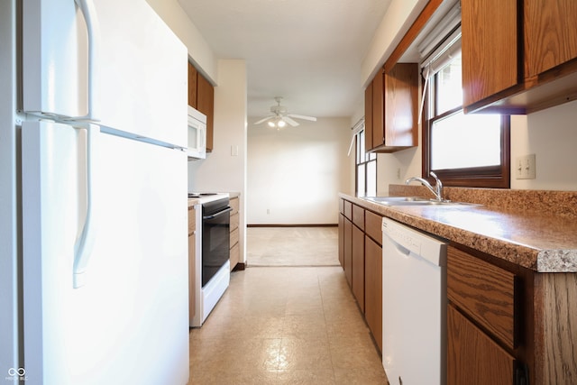 1367 Brookside Ct, Columbus, IN 47201 - kitchen with white appliances, a sink, brown cabinetry, ceiling fan, and light floors