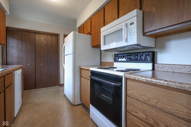 1367 Brookside Ct, Columbus, IN 47201 - kitchen featuring white appliances and brown cabinetry