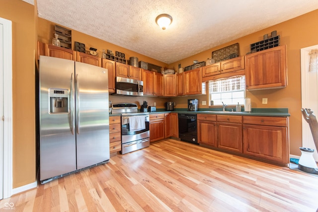 977 Canary Creek Dr, Franklin, IN 46131 - kitchen with appliances with stainless steel finishes, brown cabinets, light wood-style floors, a textured ceiling, and dark countertops
