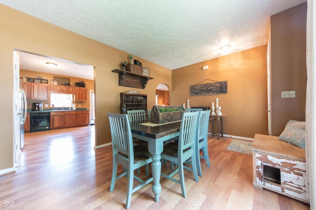 977 Canary Creek Dr, Franklin, IN 46131 - dining area with a textured ceiling, light wood-style floors, and arched walkways