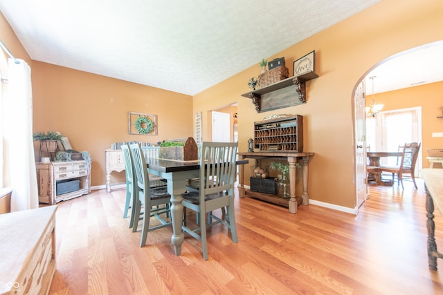 977 Canary Creek Dr, Franklin, IN 46131 - dining space with light wood-style flooring, arched walkways, and a fireplace
