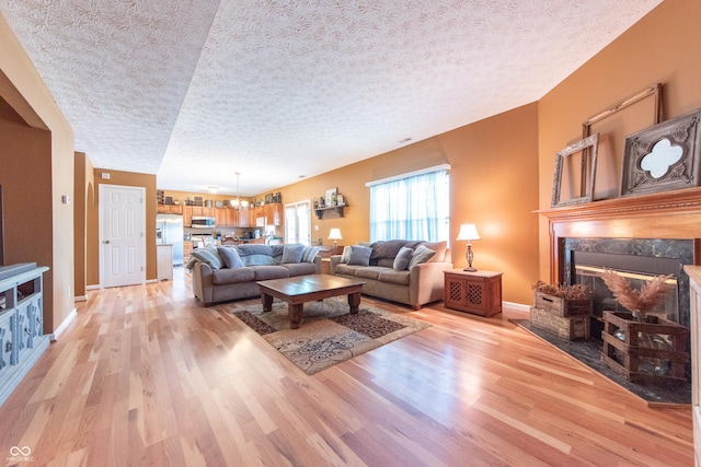 977 Canary Creek Dr, Franklin, IN 46131 - living room with light wood-style floors, a premium fireplace, and a textured ceiling