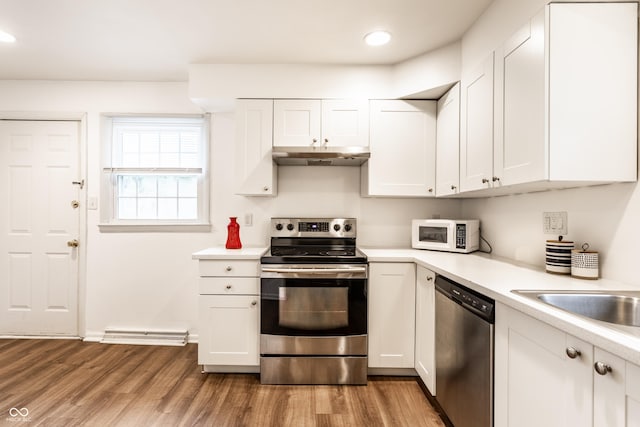 5002 E Washington St, Indianapolis, IN 46201 - kitchen with stainless steel appliances, light wood-type flooring, light countertops, white cabinets, and under cabinet range hood