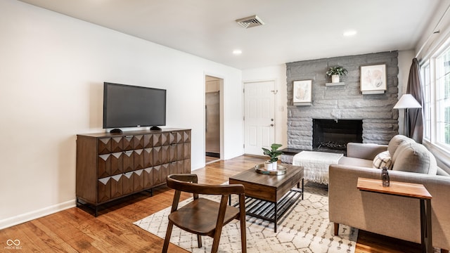 5002 E Washington St, Indianapolis, IN 46201 - living area featuring light wood finished floors, a stone fireplace, and recessed lighting