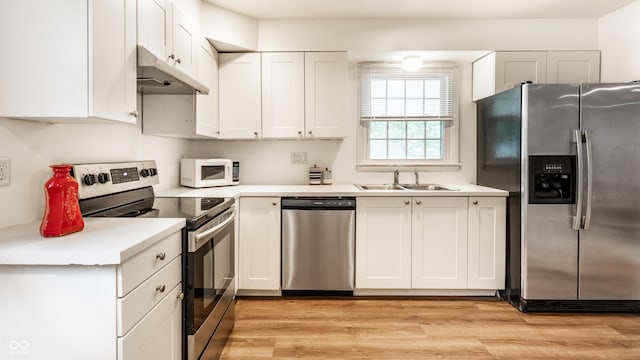5002 E Washington St, Indianapolis, IN 46201 - kitchen featuring appliances with stainless steel finishes, under cabinet range hood, white cabinets, and light countertops