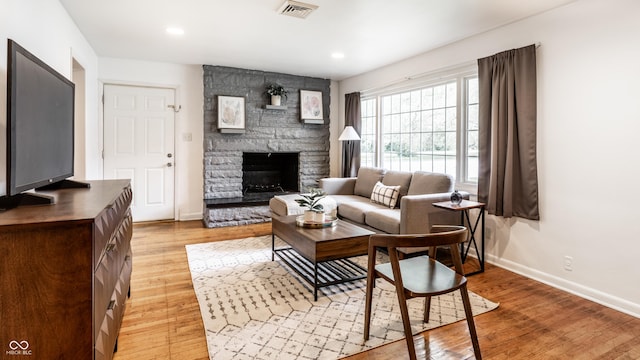 5002 E Washington St, Indianapolis, IN 46201 - living room featuring light wood-type flooring, a stone fireplace, and recessed lighting