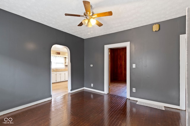1021 W 37th St, Indianapolis, IN 46208 - spare room with arched walkways, a ceiling fan, wood-type flooring, baseboards, and a textured ceiling