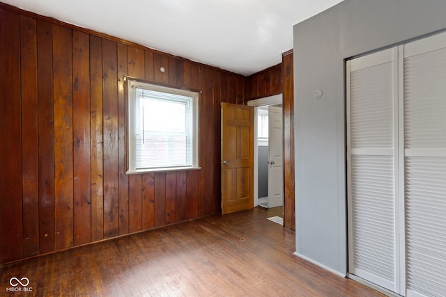 1021 W 37th St, Indianapolis, IN 46208 - unfurnished bedroom featuring wooden walls, wood finished floors, a closet, and baseboards