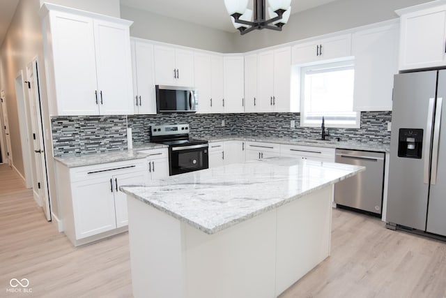 4625 W Naomi St, Indianapolis, IN 46241 - kitchen featuring appliances with stainless steel finishes, a sink, light wood-style flooring, tasteful backsplash, and white cabinets
