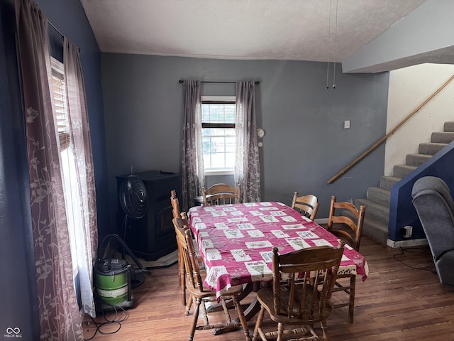 2208 S F St, Elwood, IN 46036 - dining space with wood finished floors, stairway, and a wood stove