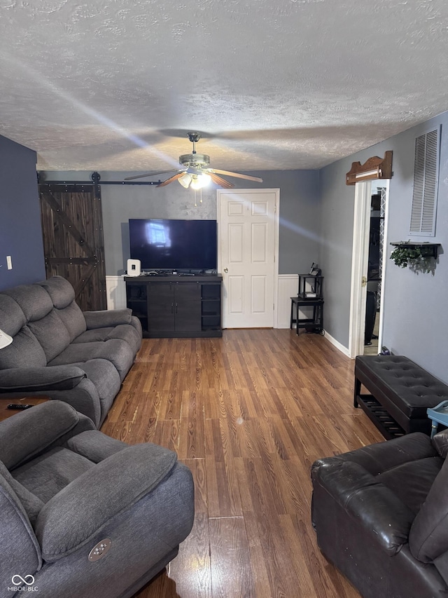 2208 S F St, Elwood, IN 46036 - living area featuring a barn door, a ceiling fan, a textured ceiling, and wood finished floors