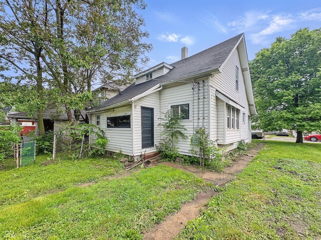 526 N Centennial St, Indianapolis, IN 46222 - view of side of home with a chimney, entry steps, and roof with shingles