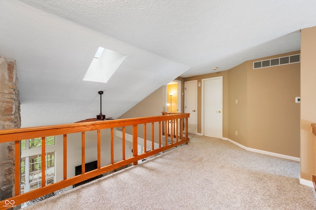 6263 Behner Way, Indianapolis, IN 46250 - corridor featuring a skylight, lofted ceiling, carpet floors, baseboards, and a textured ceiling