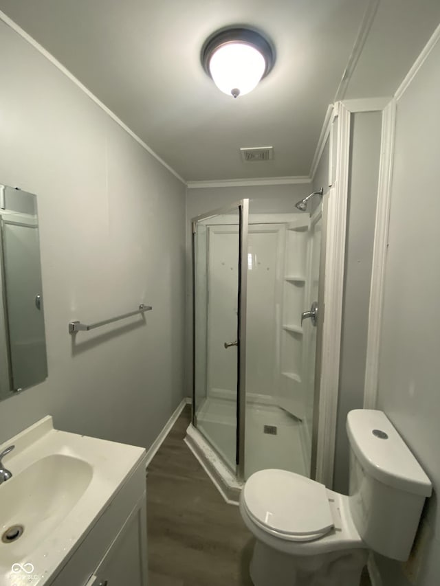 653 Birch Ave, Indianapolis, IN 46221 - bathroom with a shower stall, ornamental molding, toilet, wood finished floors, and vanity