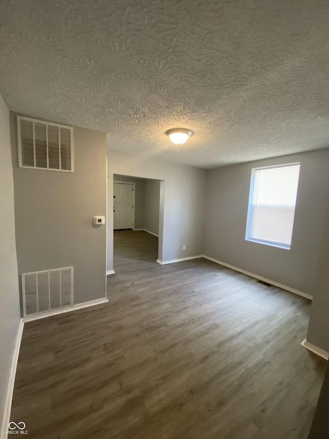 653 Birch Ave, Indianapolis, IN 46221 - spare room featuring baseboards, dark wood-style floors, and a textured ceiling